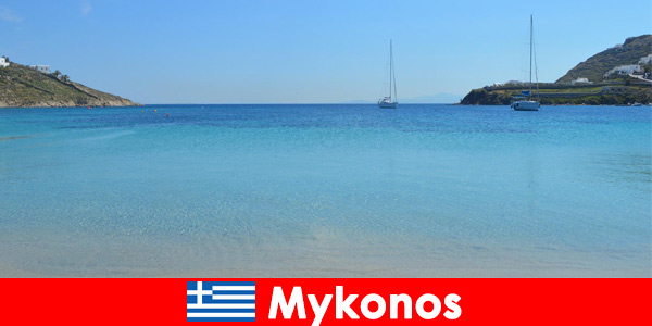 Почиващите обичат слънцето и кристално чистата вода в Миконос, Гърция